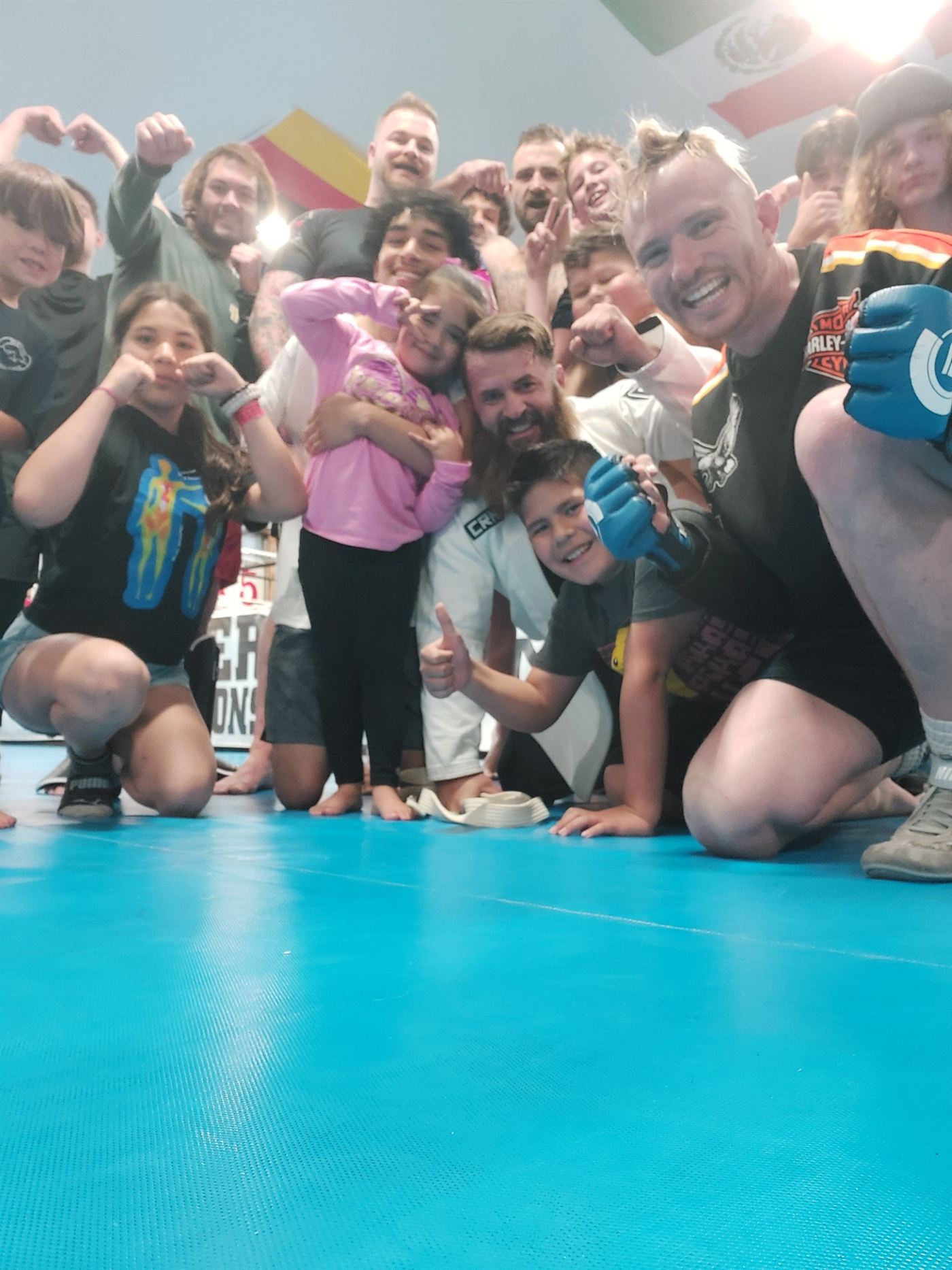 Sean Powers with students and families on the mats